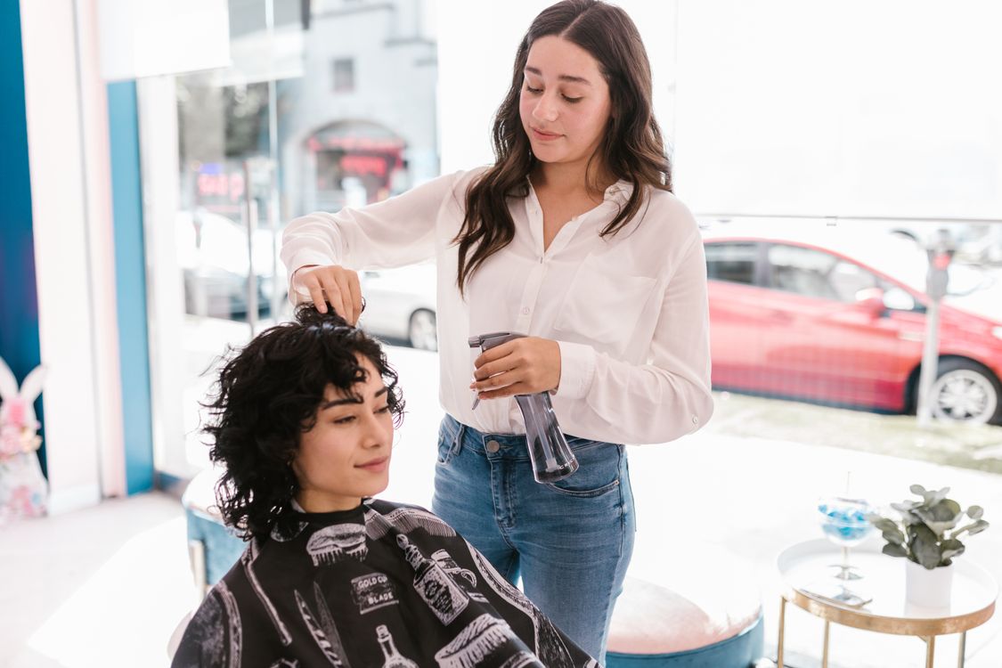 Cabeleireira profissional realizando corte de cabelo em cliente dentro de salão em Breves, Pará, Brasil