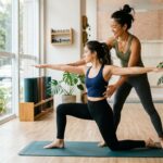 Professora pilates MEI ruiva ensinando aula em estudio iluminado com aluna no tapete